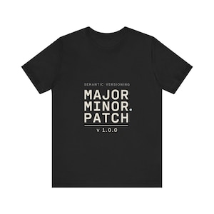 Może przedstawiać: Czarny t-shirt z krótkim rękawem z nadrukiem SEMANTIC VERSIONING, MAJOR. MINOR. PATCH oraz v 1.0.0 w jasnobeżowym kolorze na środku klatki piersiowej. Koszulka posiada okrągły dekolt i standardowy krój.