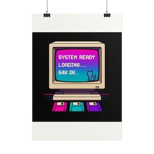 Può includere: Un poster con un monitor per computer retrò color beige che mostra uno schermo sfumato con il testo SYSTEM READY LOADING... 64K OK. e un gatto pixelato. Sotto il monitor ci sono tre floppy disk colorati in rosa, blu e viola.