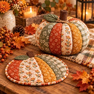 Puede incluir: Una calabaza de tela y un tapete plano a juego con forma de calabaza, ambos con paneles acolchados en patrones florales y de cuadros en naranja, verde y crema. Cada pieza tiene un tallo marr&oacute;n texturizado y una hoja de tela verde.