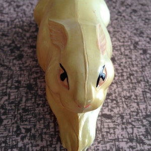 May include: A yellow rubber toy rabbit with black eyes and a pink nose.