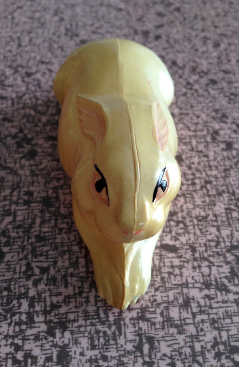 May include: A yellow rubber toy rabbit with black eyes and a pink nose.