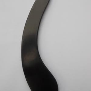 Può includere: Uno strumento gua sha liscio di colore grigio antracite scuro con una forma curva ed ergonomica. L'oggetto presenta un'estremità affusolata e una base più ampia e arrotondata, con una finitura opaca uniforme su tutta la superficie senza segni.