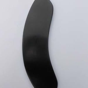 Op de afbeelding: Een gladde, massief zwarte gua sha-tool met een gebogen, langwerpige halvemaanvorm. Het object heeft een afgeronde bovenkant en een licht taps toelopende onderrand, met een uniforme matte afwerking over het gehele oppervlak tegen een lichte achtergrond.