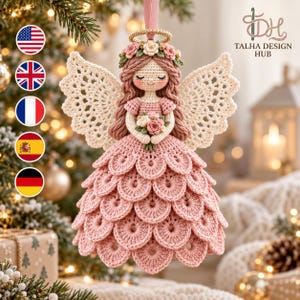 Op de afbeelding: Een gehaakte engel-ornament met een oudroze gelaagde rok, crèmekleurige kantachtige vleugels en een bloemenkrans. De figuur heeft gevlochten haar, een gouden halo en houdt een boeketje vast. De tekst luidt TALHA DESIGN HUB.