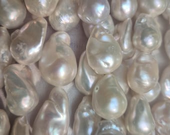 May include: A collection of white baroque pearls with irregular, organic shapes and a high-luster, iridescent finish. Each pearl displays unique surface textures and subtle rainbow-like reflections, clustered together in a dense arrangement.