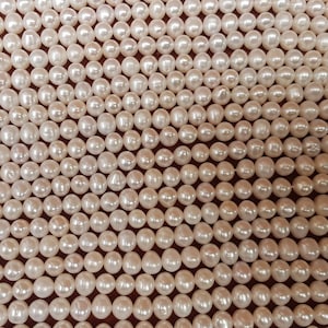 Perles d'eau douce ivoire presque rondes de 8 mm. Chaque corde mesure 15 pouces. Haute brillance. 52 perles par fil.