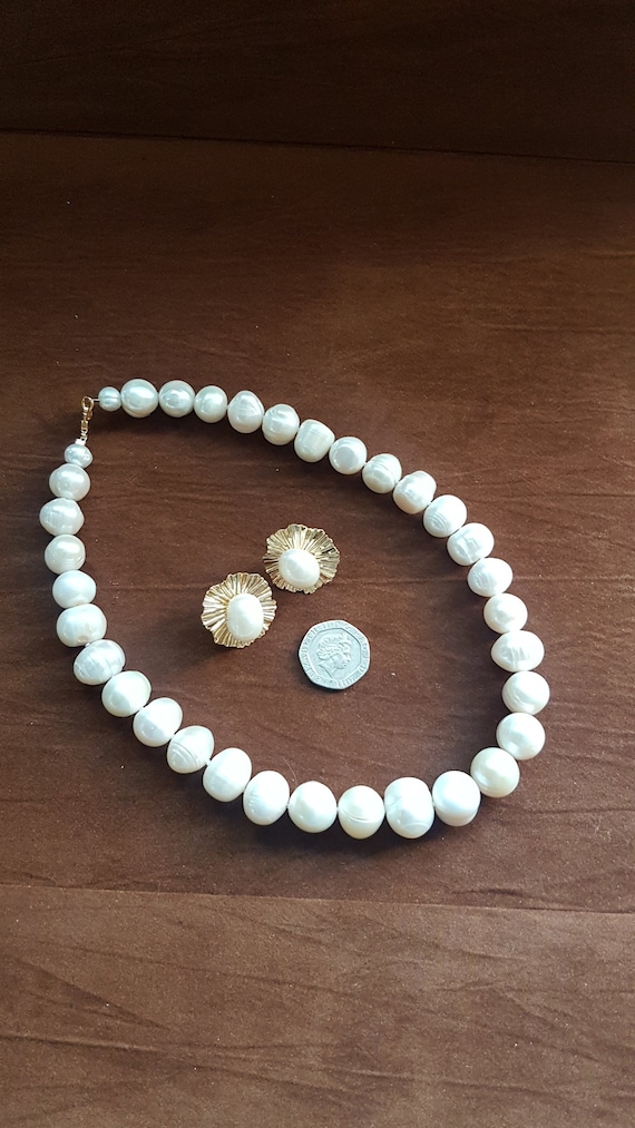 Freshwater graduated pearl necklace with earrings. Beads are 12x16mm approx. 18 inch necklace. Beads are AA+ ringed pearls.