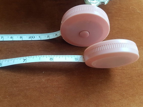 Retractable measuring tape. Metric and imperial and two-sided. For craft and design projects. Pastel pink, pastel green & pastel blue.