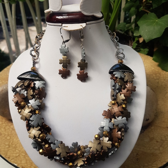 Matte dyed and polished 3 tone hematite beads 4 petal floral bead design. Quite understated piece.
