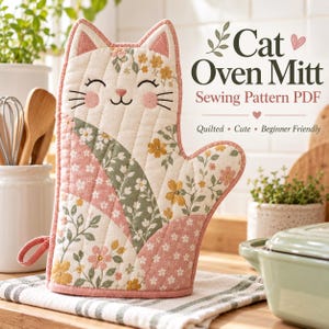 Op de afbeelding: Een gewatteerde ovenwant in de vorm van een kat met een bloemenpatroon in roze, groene en gele tinten. De tekst op de afbeelding luidt: Cat Oven Mitt Sewing Pattern PDF, Quilted, Cute, Beginner Friendly. De want heeft een ophanglus.