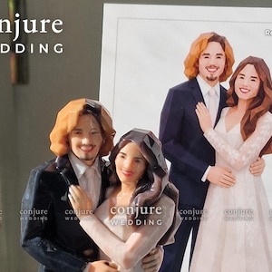 May include: A 3D printed wedding cake topper featuring a couple with a low-poly geometric design. The figure shows a person with shoulder-length brown hair in a dark suit and a person with long dark hair in a white dress. Text reads conjure WEDDING.