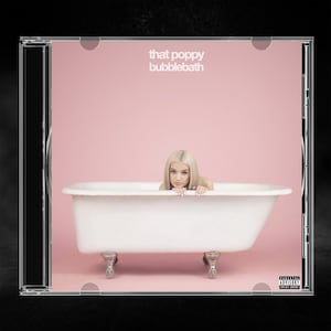 May include: A CD case featuring the album cover for That Poppy Bubblebath. The artwork shows a person with blonde hair inside a white clawfoot bathtub against a solid pink background. The text reads that poppy bubblebath.