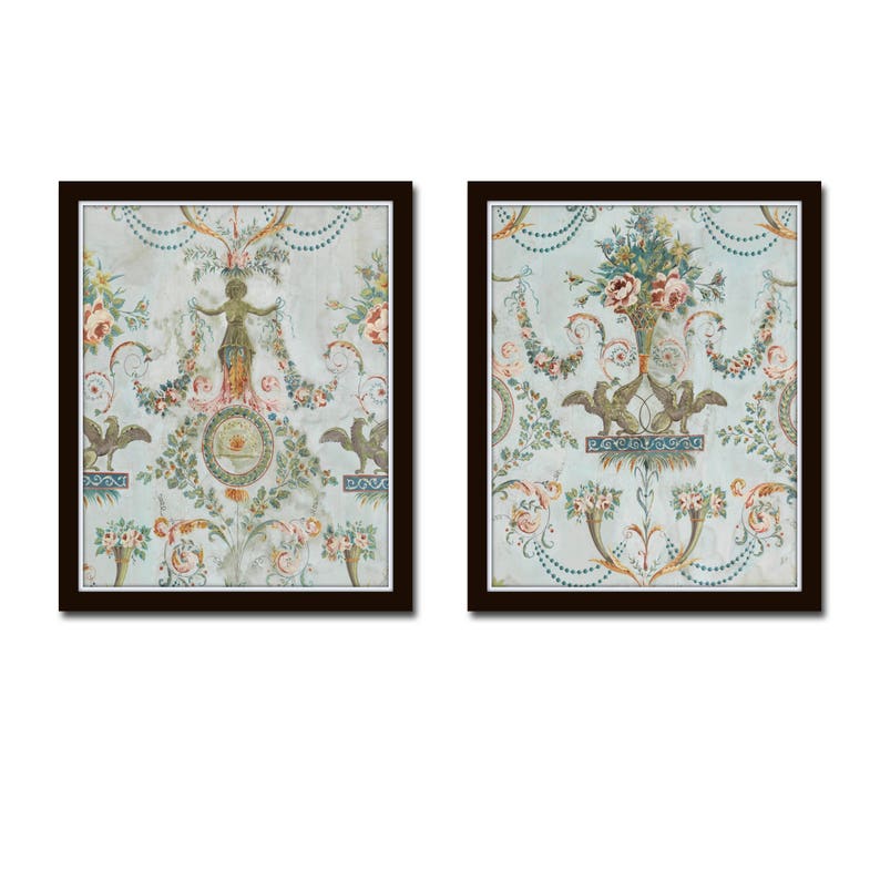May include: Two framed prints with a vintage floral design. The prints feature a light blue background with intricate floral patterns in shades of green, pink, and yellow. The floral designs are framed in a dark brown wood frame.