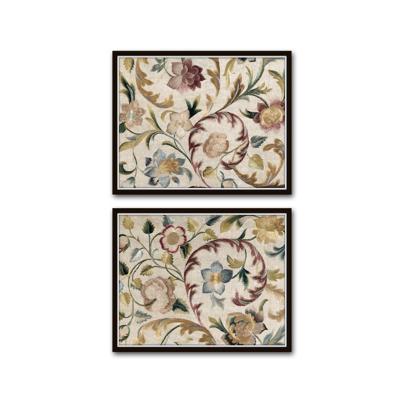 Op de afbeelding: Twee ingelijste bloemenkunstprints. Elke print heeft een cr&egrave;mekleurige achtergrond met een herhalend patroon van bloemen en bladeren in tinten bordeauxrood, blauw, groen en goud. De frames zijn donkerbruin.