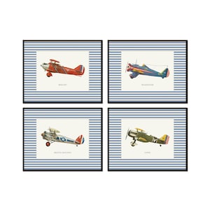 May include: Four framed prints featuring vintage airplane illustrations. Each print has a blue and white striped background and a black frame. The airplanes are in various colors, including red, blue, green, and yellow, with the names of the planes printed below.