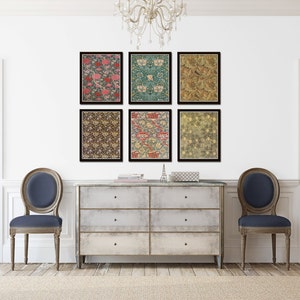 May include: Six framed prints of floral patterns in various colors, including red, green, and gold, are displayed on a white wall above a light-colored dresser with six drawers. Two blue chairs are placed on either side of the dresser.