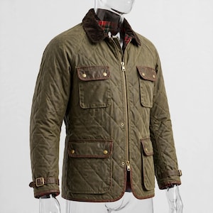 May include: An olive green quilted jacket featuring a brown corduroy collar, a front zipper closure, and four flap pockets with brass-toned snap buttons. The cuffs include adjustable buckled straps, and the interior lining displays a red plaid pattern.