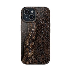 May include: A smartphone case featuring a dark brown and black snakeskin pattern with a realistic scale texture. The case has a rectangular shape with rounded corners and a circular cutout at the top left for a dual camera system and flash.