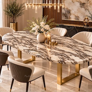 Puede incluir: Una mesa de comedor ovalada con un tablero de mármol veteado en blanco y marrón oscuro sobre una base de metal dorado. La mesa está rodeada por seis sillas con tapicería color crema en el frente y tela marrón oscuro detrás.