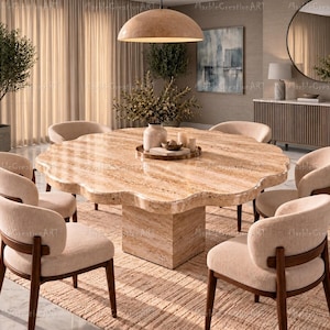 Op de afbeelding: Een ronde eettafel met geschulpte randen van beige travertijnsteen met een dikke, vierkante voet. De tafel is omringd door zes stoelen met gebogen, gestoffeerde rugleuningen in een lichte crèmekleurige stof en donkerhouten frames.