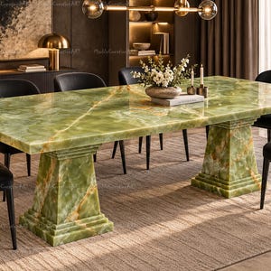 May include: A rectangular dining table featuring a polished green onyx stone top with natural veining and two matching pedestal bases. The table is surrounded by six black upholstered chairs with thin metal legs.