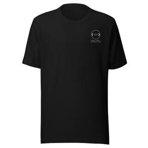 Könnte beinhalten: Ein schwarzes Kurzarm-T-Shirt mit einer kleinen weißen kreisförmigen Grafik auf der linken Brust. Die Grafik enthält ein Code-Klammer-Symbol und den Text "I copy, I paste, therefore I Vibe" in einer klaren, weißen serifenlosen Schrift.