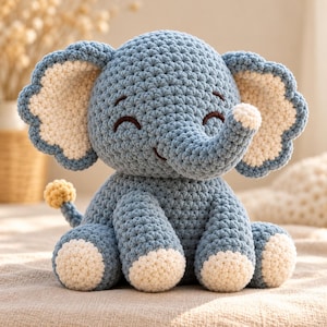 Può includere: Un peluche a forma di elefante realizzato all'uncinetto con filato blu polvere e crema. Il giocattolo presenta grandi orecchie smerlate con centri color crema, una proboscide curva e occhi chiusi. I piedi e la punta della coda sono crema.