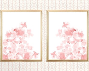 May include: Two framed prints with a watercolor design of pink flowers on a white background. The frames are gold and have a simple, modern design.