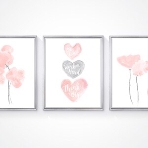 May include: Three framed prints with watercolor illustrations. The left print features pink flowers. The center print features three hearts with the text "Be Kind", "Work Hard", and "Think Big". The right print features pink flowers.
