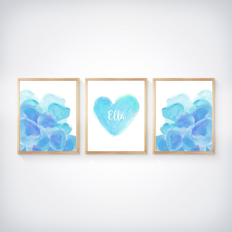 May include: Three framed watercolor prints with a blue and purple color scheme. The center print features a heart shape with the name "Ella" written inside. The prints are perfect for a nursery or child's room.
