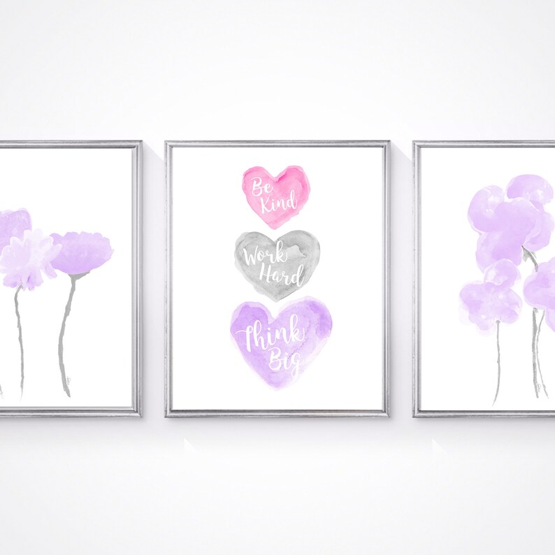 May include: Three watercolor prints with a white background. The center print features three hearts with the words "Be Kind", "Work Hard", and "Think Big" written in white. The left and right prints feature purple watercolor flowers.