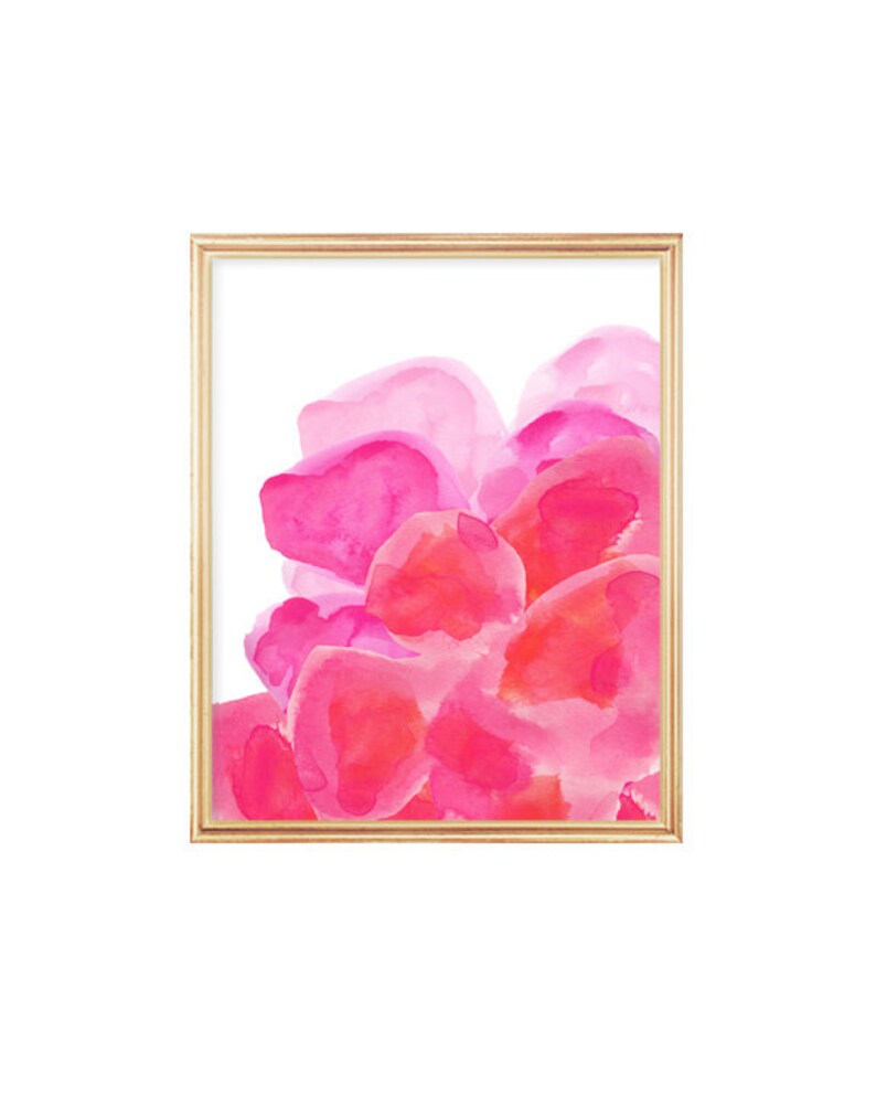 May include: Abstract watercolor painting with pink and red hues, resembling flower petals. The painting is framed in a gold frame.