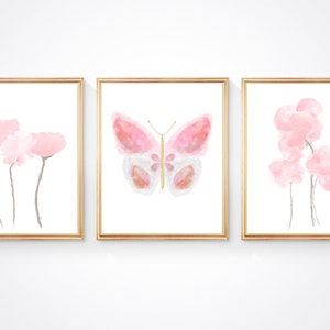 May include: Three framed watercolor prints with a pink butterfly in the center and pink flowers on either side.