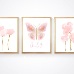 May include: Three framed prints with watercolor illustrations of pink flowers and a butterfly. The center print features the name "Charlotte".