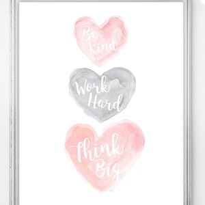 May include: Three watercolor hearts with inspirational messages: Be Kind, Work Hard, Think Big. The hearts are stacked vertically, with the top heart in pink, the middle heart in gray, and the bottom heart in pink.