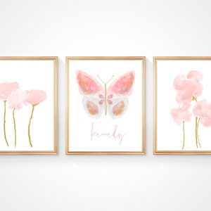 May include: Three framed prints with watercolor illustrations of pink flowers and a butterfly. The middle print has the name "Kennedy" written in pink script.