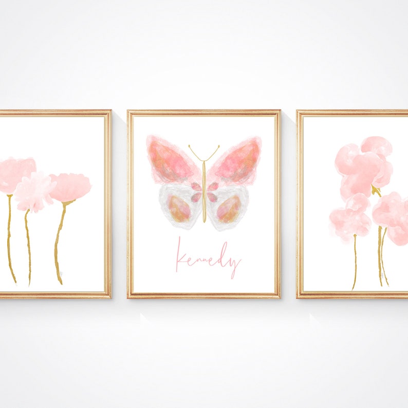 May include: Three framed prints with watercolor illustrations of pink flowers and a butterfly. The middle print has the name "Kennedy" written in pink script.