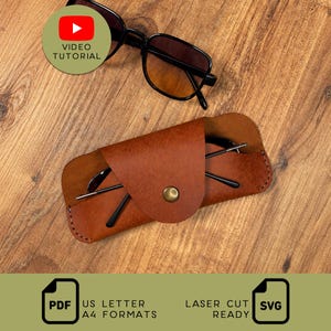 May include: A brown leather glasses case with a metal snap button closure, containing a pair of black-framed glasses with gradient lenses. A separate pair of black-framed glasses sits above the case. Text includes VIDEO TUTORIAL, PDF US LETTER A4 FORMATS, and LASER CUT READY SVG.