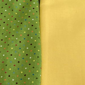May include: Two fabric swatches, one green with multicolored polka dots and one solid yellow.