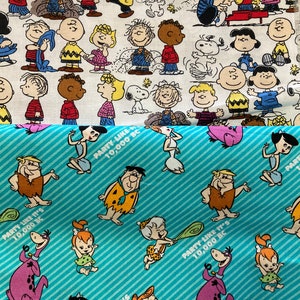May include: A white fabric with a repeating pattern of cartoon characters from the Peanuts comic strip. The fabric is printed with images of Charlie Brown, Snoopy, Lucy, Linus, and other characters. The fabric is also printed with the text "PARTY LIKE IT'S 10,000 BC".