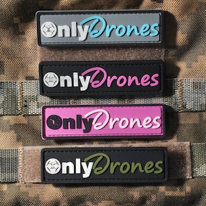 May include: Four rectangular morale patches featuring the text "onlyDrones" with a drone icon. The top patch is grey with light blue text, the second is black with pink text, the third is pink with black text, and the bottom is black with olive green text.