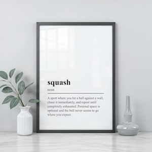 May include: A framed wall art print featuring a dictionary-style definition of the word squash as a noun, describing it as a sport where you hit a ball against a wall, chase it immediately, and repeat until completely exhausted.
