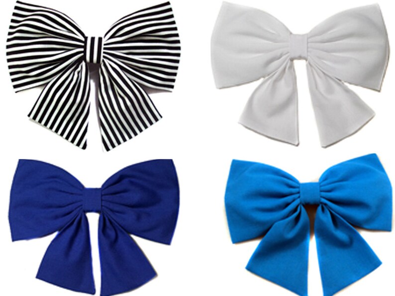 May include: Four fabric bows in different colors: black and white striped, white, blue, and a darker blue. The bows are all tied in the same way, with the two loops crossing over each other in the center.