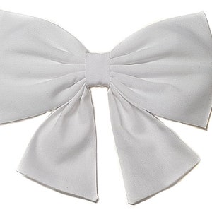 May include: A large white bow made of fabric. The bow is tied in a classic style with two loops and a center knot.