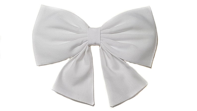 May include: A large white bow made of fabric. The bow is tied in a classic style with two loops and a center knot.