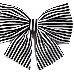 May include: A large black and white striped bow. The bow is made of fabric and has a classic shape.