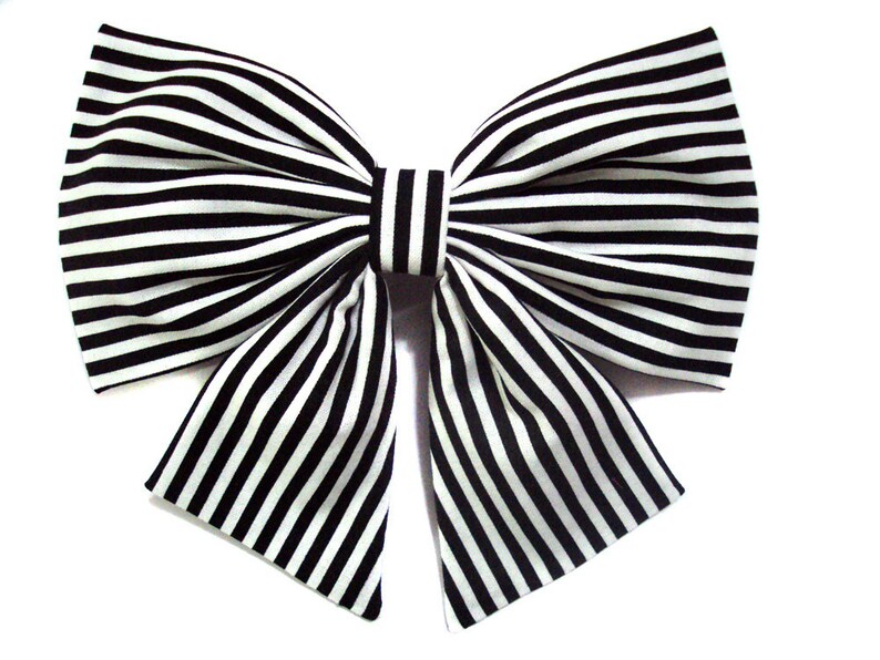 May include: A large black and white striped bow. The bow is made of fabric and has a classic shape.