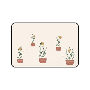 Puede incluir: Una alfombra rectangular con fondo color crema y borde negro. La superficie presenta un patrón repetitivo de cinco plantas en macetas de color terracota, cada una con hojas verdes y un pequeño detalle circular de color amarillo.