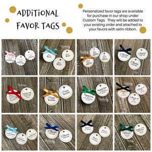 May include: Assortment of round, white, paper favor tags with black text and various designs. The tags are tied with satin ribbon in different colors, including red, blue, green, and gold. The tags feature text such as "Cheers to 50 Years", "Happy Birthday", "Thank You", and "It's a Boy".