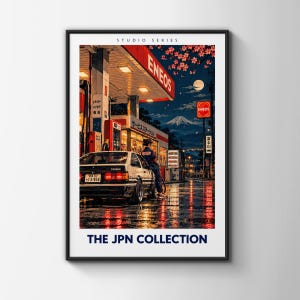 May include: A framed art print titled THE JPN COLLECTION featuring a night scene at an ENEOS gas station with a person leaning against a white and black Toyota Trueno. Mount Fuji is visible in the background under a full moon and cherry blossoms.